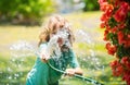 Kids play with water garden hose in yard. Outdoor children summer fun. Little boy playing with water hose in backyard Royalty Free Stock Photo