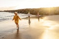 Kids playing on the beach. Little boy and girls running at sea shore at sunset. Family summer vacation vibes