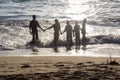 Kids playing at the beach at sunset