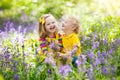 Kids playing in blooming garden with bluebell flowers