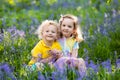 Kids playing in blooming garden with bluebell flowers Royalty Free Stock Photo