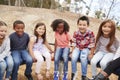 Kids playing on a carousel in schoolyard looking to camera Royalty Free Stock Photo