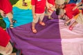 Kids playing on colorful cloth at a field day activity