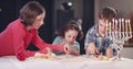 Kids playing with dreidels during Hanukka at home