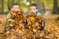 Kids playing with fallen leaves in autumn park Royalty Free Stock Photo