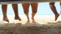 Kids playing with feet dangling at sea