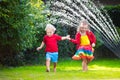 Kids playing with garden sprinkler Royalty Free Stock Photo