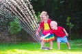 Kids playing with garden sprinkler Royalty Free Stock Photo