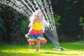 Kids playing with garden sprinkler
