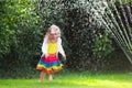 Kids playing with garden sprinkler Royalty Free Stock Photo