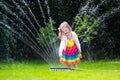 Kids playing with garden sprinkler Royalty Free Stock Photo