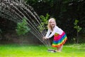 Kids playing with garden sprinkler Royalty Free Stock Photo