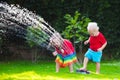 Kids playing with garden sprinkler Royalty Free Stock Photo