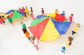 Kids playing parachute games at school sports hall