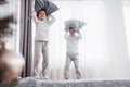 Kids playing in parents bed. Children wake up in sunny white bedroom. Boy and girl play in matching pajamas. Family Royalty Free Stock Photo