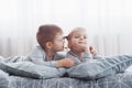 Kids playing in parents bed. Children wake up in sunny white bedroom. Boy and girl play in matching pajamas. Sleepwear Royalty Free Stock Photo