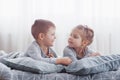 Kids playing in parents bed. Children wake up in sunny white bedroom. Boy and girl play in matching pajamas. Sleepwear Royalty Free Stock Photo