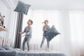 Kids playing in parents bed. Children wake up in sunny white bedroom. Boy and girl play in matching pajamas. Sleepwear Royalty Free Stock Photo