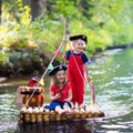 Kids playing pirate adventure on wooden raft Royalty Free Stock Photo