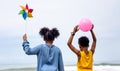 Kids playing running on sand at the beach, A group of children holding hands in a row on the beach in summer, rear view against Royalty Free Stock Photo