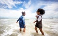 Kids playing running on sand at the beach, A group of children holding hands in a row on the beach in summer, rear view against Royalty Free Stock Photo