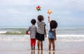 Kids playing running on sand at the beach, A group of children holding hands in a row on the beach in summer, rear view against Royalty Free Stock Photo