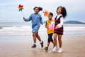 Kids playing running on sand at the beach, A group of children holding hands in a row on the beach in summer, rear view against Royalty Free Stock Photo