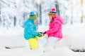 Kids playing in snow. Children play outdoors in winter snowfall. Royalty Free Stock Photo