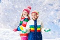 Kids playing in snow. Children play outdoors in winter snowfall Royalty Free Stock Photo