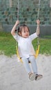 Kids playing at the swing in the playground Royalty Free Stock Photo