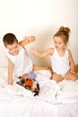 Kids playing with their kitten on the bed Royalty Free Stock Photo