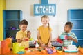 Kids playing with toy kitchen at entertainment center. Royalty Free Stock Photo