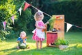 Kids playing with a toy kitchen in a summer garden Royalty Free Stock Photo