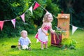 Kids playing with a toy kitchen in a summer garden Royalty Free Stock Photo