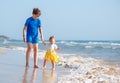 Kids playing on tropical beach. Big brother together with his little sister at sea shore at sunset. Family summer vacation. Royalty Free Stock Photo