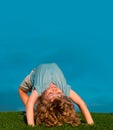 Kids playing upside down on grass outdoors in summer park. Children playing on nature. Copy space on blue sky. Royalty Free Stock Photo