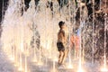 Kids playing in water fountain at night Royalty Free Stock Photo