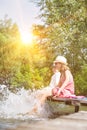 Kids playing water while sitting in pier at lake Royalty Free Stock Photo