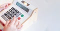 Kids are playing a wooden toy cash register by pressing the number seven, and others on it, respectively Royalty Free Stock Photo