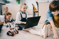 kids programming robot while sitting on floor at stem