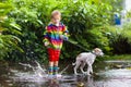 Kids in puddle in autumn rain. Waterproof wear Royalty Free Stock Photo