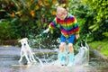 Kids in puddle in autumn rain. Waterproof wear Royalty Free Stock Photo