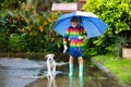 Kids in puddle in autumn rain. Waterproof wear Royalty Free Stock Photo