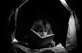 Kids reading books. Dreaming child in kids tent read bedtime stories, fairystory or fairytale.