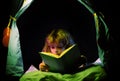 Kids reading books. Dreaming child in kids tent read bedtime stories, fairystory or fairytale.