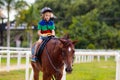 Kids ride horse. Child on pony. Horseback riding