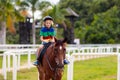 Kids ride horse. Child on pony. Horseback riding Royalty Free Stock Photo