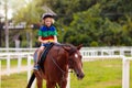 Kids ride horse. Child on pony. Horseback riding