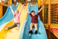 Kids riding from childrens slides in game center Royalty Free Stock Photo