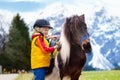 Kids riding pony. Child on horse in Alps mountains Royalty Free Stock Photo